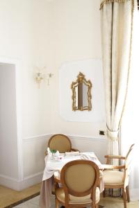 uma sala de jantar com uma mesa, cadeiras e um espelho em Hotel Villa Pinciana em Roma