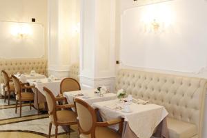 a restaurant with tables and chairs with white tablecloths at Hotel Villa Pinciana in Rome