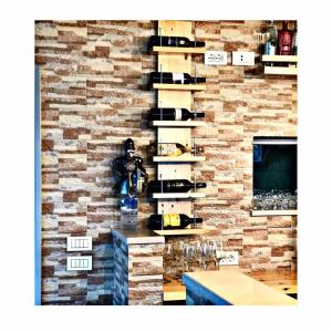 uma parede de tijolos com uma prateleira de copos de vinho em Belvedere Hotel & Suites em Himare