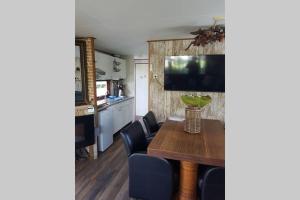 cocina y comedor con mesa y sillas en Stuyvesanthof scheldeoord chalet 710, en Baarland