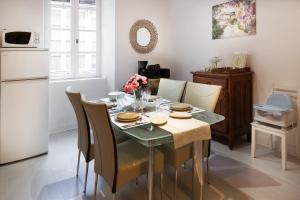a dining room with a table with chairs and a refrigerator at Le Logis - lescapade-medievale Sarlat in Sarlat-la-Canéda +21 photos