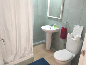 a bathroom with a white toilet and a sink at Apartamentos Rocamar el Medano in El Médano
