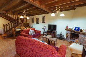 a living room with two red couches and a fireplace at Casa Rural La Galana in Sames