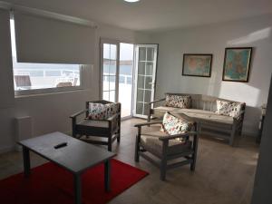 a living room with chairs and a couch and a table at Apartamentos Rocamar el Medano in El Médano