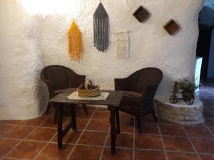 stół i krzesła w pokoju ze ścianą w obiekcie Casa Rural Cueva El Sauce w mieście Pegalajar