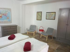a bedroom with two beds and two chairs and a dresser at Apartamentos Rocamar el Medano in El Médano