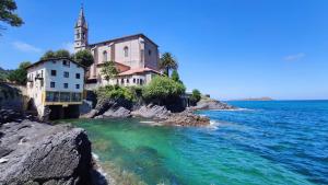 eine Gruppe von Gebäuden am Ufer eines Wasserkörpers in der Unterkunft Mundaka Sea Apartment in Mundaka