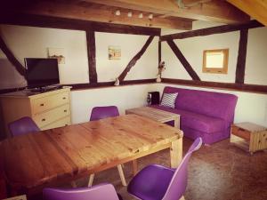a living room with a wooden table and purple couch at Ferienhaus am Radwanderweg in Klausdorf Mecklenburg Vorpommern