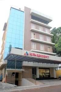un grand bâtiment rose avec un panneau sur lui dans l'établissement Aura Residency, à Thrissur