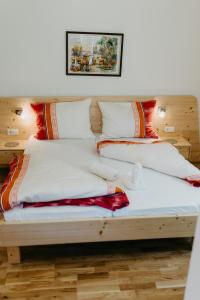 a bed with four pillows on top of it at Appartement VIDMAR-FERIENGLÜCK in Arriach