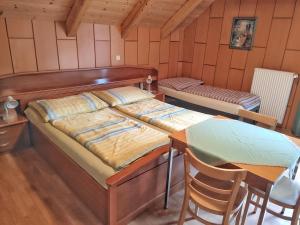 a bedroom with a bed and a table and chairs at Gästehaus Laßnig in Ebene Reichenau