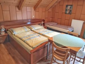 Schlafzimmer mit einem Bett, einem Tisch und Stühlen in der Unterkunft Gästehaus Laßnig in Ebene Reichenau