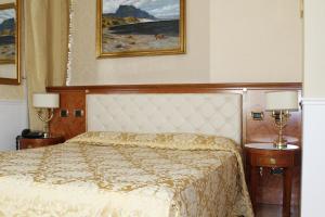 a bedroom with a bed and two night stands with lamps at Hotel Villa Pinciana in Rome