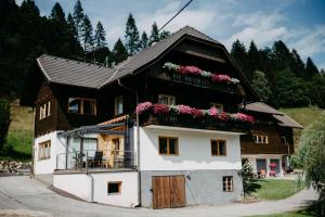 a house with flowers on the balcony of it at Appartement VIDMAR-FERIENGLÜCK in Arriach