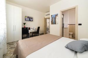 1 dormitorio con cama blanca y escritorio en Bell'Albenga en Albenga