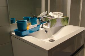 un lavandino in bagno con tazze blu sopra di Pension Lärchenhof a Döbriach Altre 37 foto