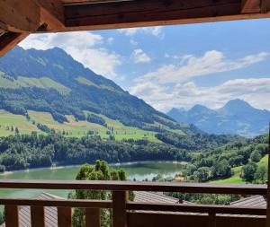 a view from the balcony of a cabin overlooking a river and mountains at Le Vieux Chalet in Crésuz