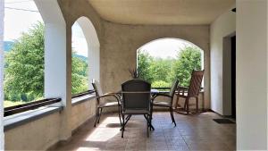 a room with a table and chairs and windows at Villa Iva in Rakovica
