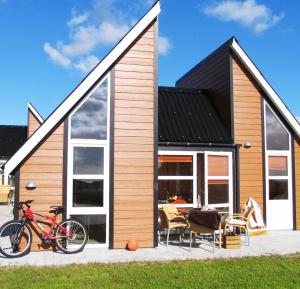 una casa con una bicicleta estacionada frente a ella en Kattegat Strand Camping en Øster Hurup