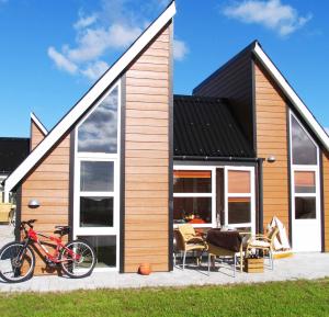 a house with a bike parked in front of it at Kattegat Strand Camping in Øster Hurup