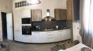 a kitchen with white cabinets and a black counter top at Cà Nicola 2 in Cortemaggiore