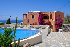 a villa with a swimming pool and a building at Pension The Flower in Oia