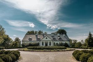 a house with a gray roof and a driveway at Dwór Mościbrody in Siedlce