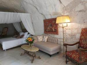 a bedroom with a bed and a couch and a table at Le Manoir des Roches in Bourré