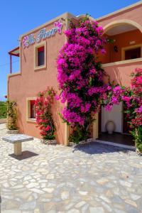 a building with pink flowers on the side of it at Pension The Flower in Oia