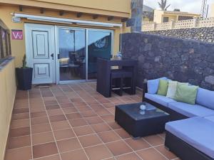 a patio with a couch and a table at Nautilus I: Casa con terraza y vistas al mar in La Caleta