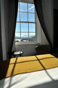 a bedroom with a bed and a window with a view at Marmalade in Portree