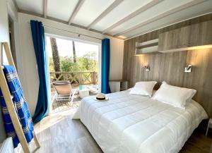 una camera con un letto bianco e una grande finestra di Airial du Seignanx a Ondres