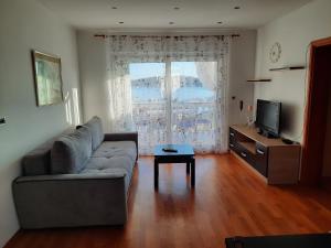 a living room with a couch and a television at Apartman Martina in Rab