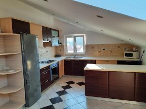a kitchen with wooden cabinets and a stainless steel refrigerator at Apartman Martina in Rab