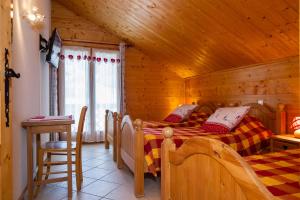 a bedroom with two beds in a wooden cabin at CHAMBRE d'HÔTE LA PETITE BERGERIE in La Chapelle-dʼAbondance