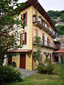 ein gelbes Gebäude mit Fenstern und Balkonen in der Unterkunft All'Antico Convento in Cannero Riviera