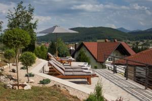 a patio with lounge chairs and an umbrella at Apartment Mario in Otočac