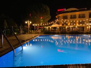 a swimming pool in front of a building at night at Motali Life Hotel in Masukiye