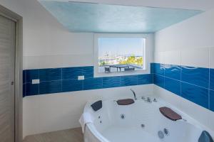 ein Bad mit einer Badewanne und einem Fenster in der Unterkunft Bali - BeDreams in Gaeta