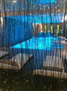 una piscina azul con escaleras y césped en Montana Chalet Hôtel & Spa, en Le Sauze