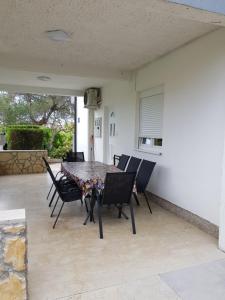 un patio con mesa de comedor y sillas en Apartment Valeria, en Lopar