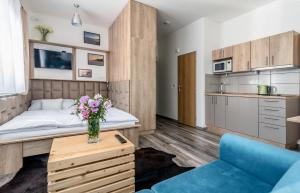 um pequeno apartamento com uma cama e um sofá azul em Modern fully equipped studio with parking Zavadilka 2620 em České Budějovice