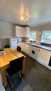 a kitchen with a wooden table and a table and a dining room at The Nook in Embleton