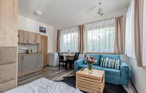 uma sala de estar com um sofá azul e uma cozinha em Modern fully equipped studio with parking Zavadilka 2620 em České Budějovice