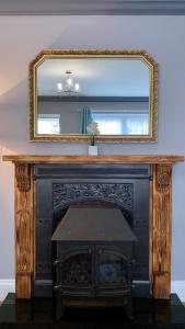 a fireplace with a mirror on top of it at The Nook in Embleton