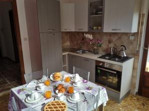uma cozinha com uma mesa com pratos de comida em App.Violet Sardegna Mare La Caletta em La Caletta