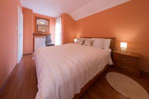 a bedroom with a large bed with orange walls at Apartment Mario in Otočac
