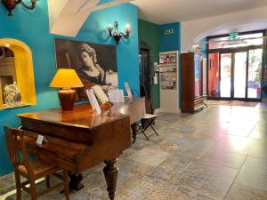 una stanza con un pianoforte e un dipinto sul muro di Hotel Il Guercino a Bologna