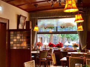 um restaurante com mesas e cadeiras e uma grande janela em Hotel Haus Deckers em Geldern