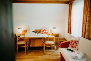 salon ze stołem, krzesłami i kanapą w obiekcie Ferienwohnung Vidmar w mieście Arriach